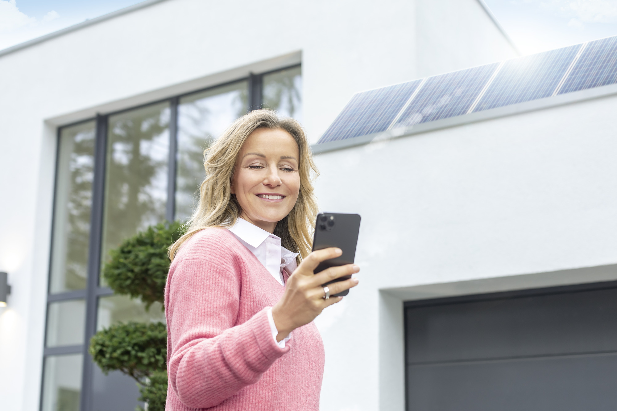 Frau nutzt den MENNEKES Wallbox Konfigurator auf ihrem Handy